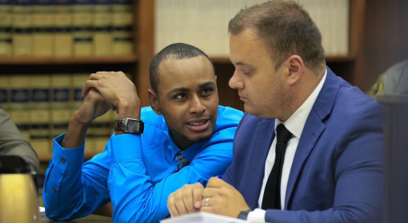 Marc Kohnen conferring with client Robert Branch at the counsel table during trial